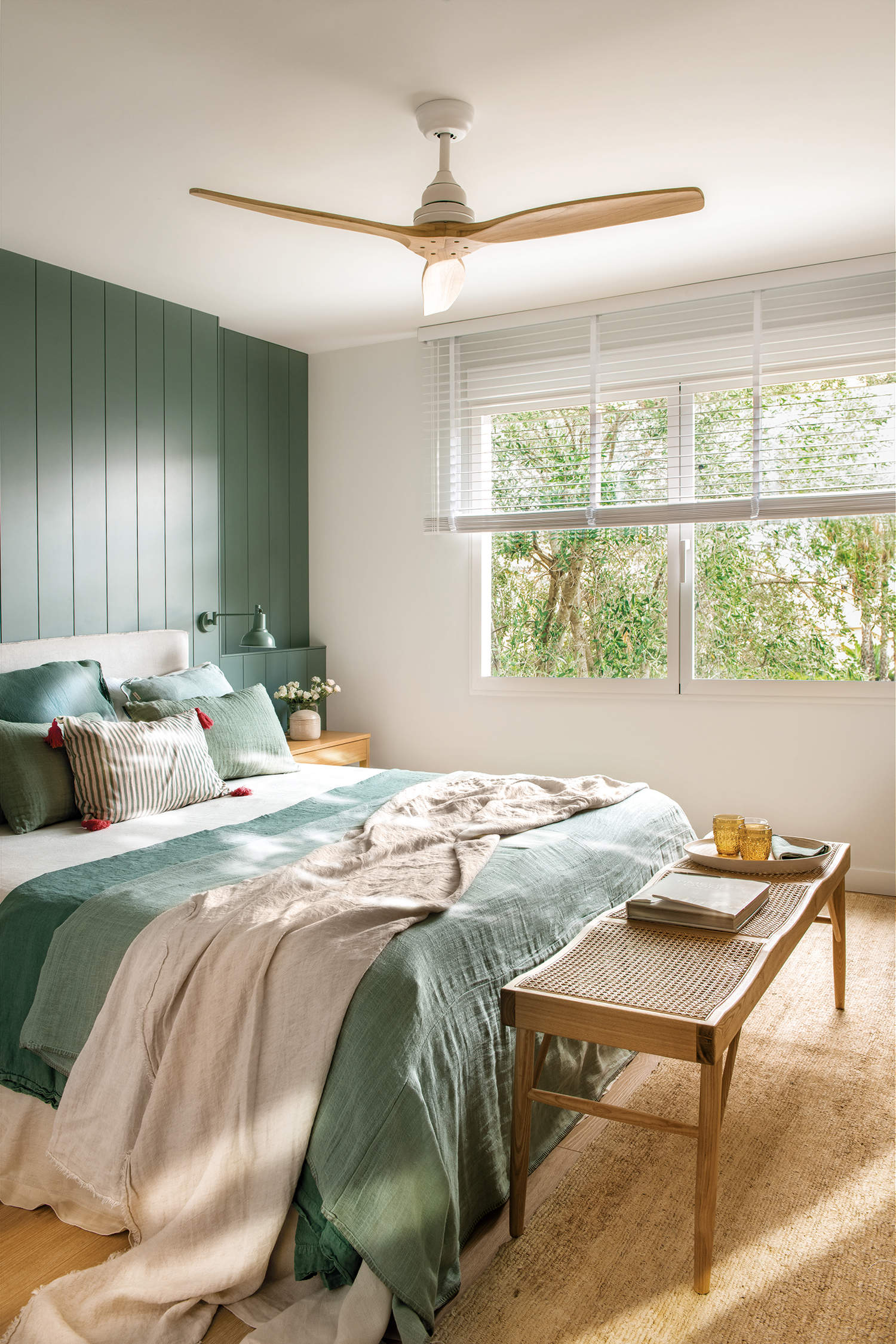 Dormitorio rústico y cálido con cabezal de madera y ropa de cama verde